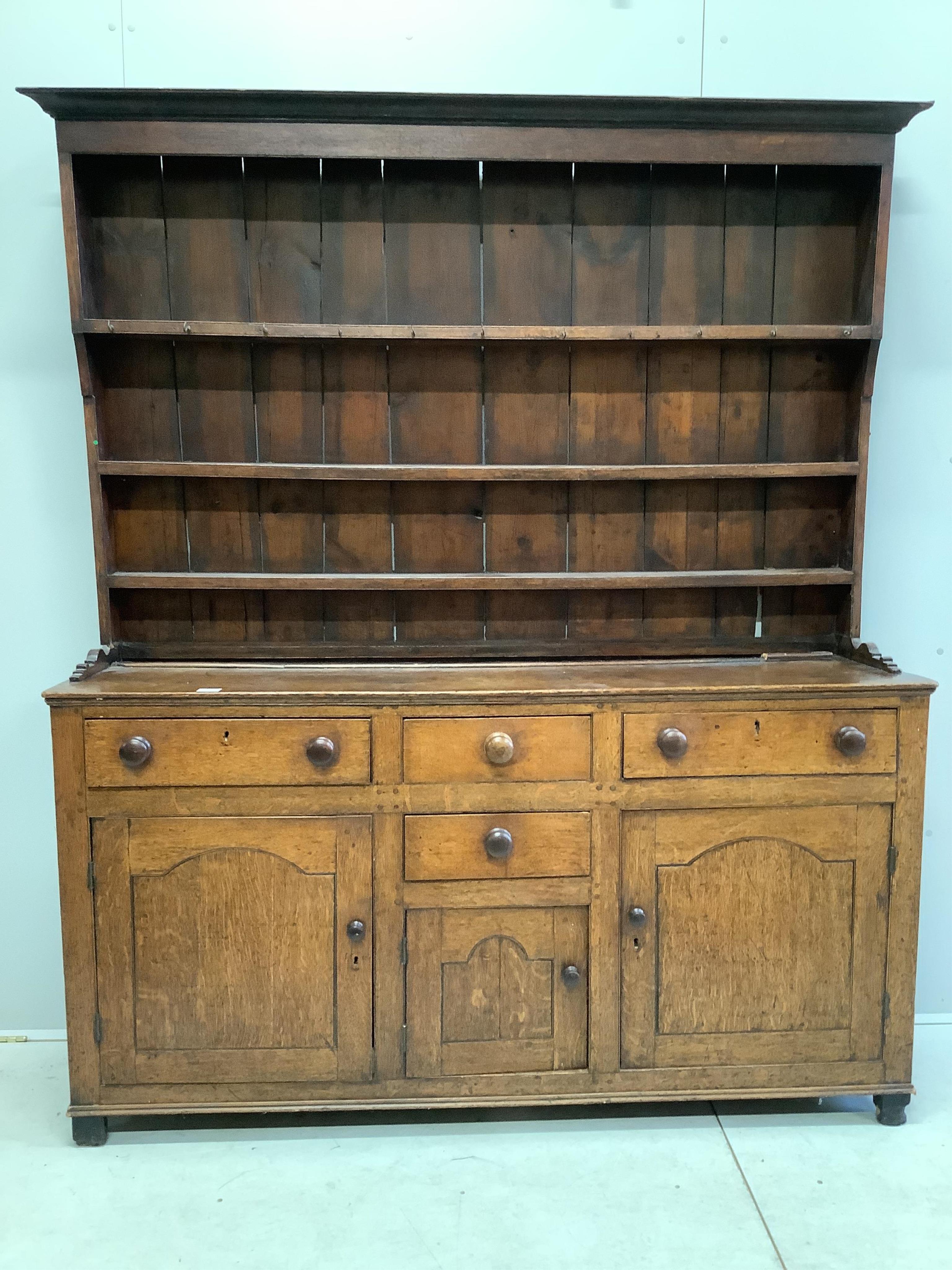 A George III oak dresser with boarded rack, width 168cm, depth 46cm, height 204cm. Condition - poor, lacks back legs